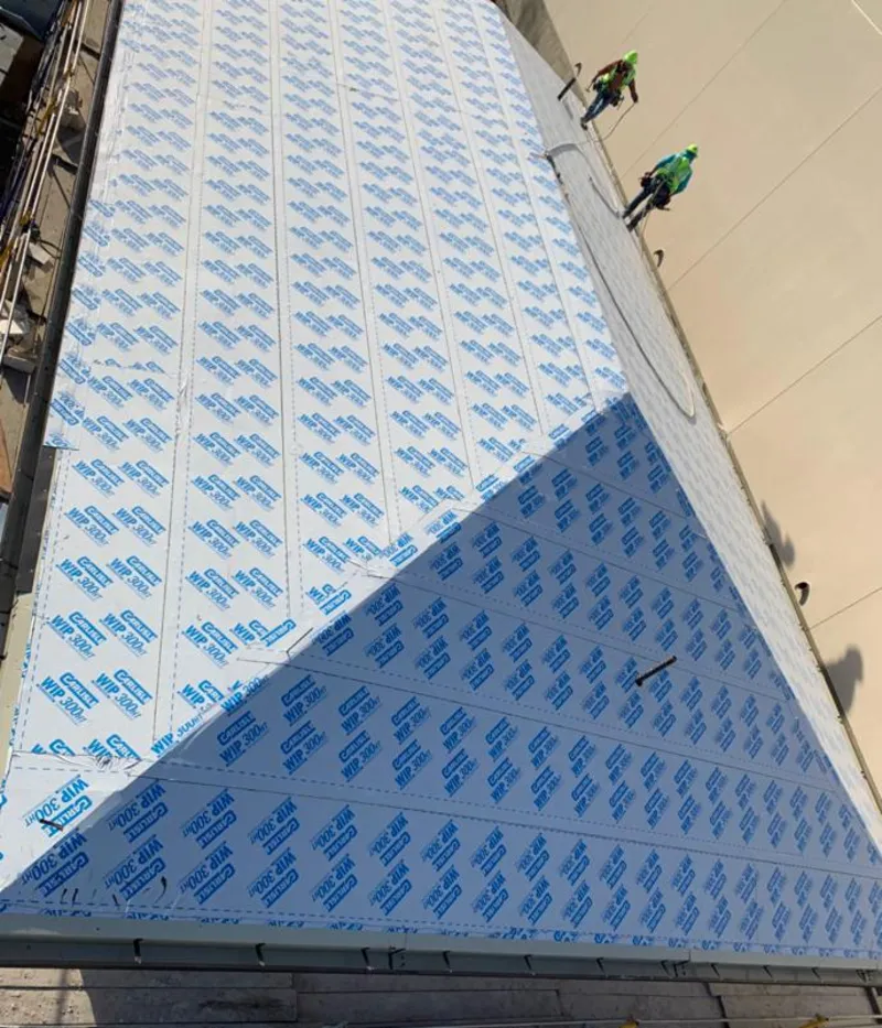 Professional roofers installing underlayment on a metal roof in Homer Glen